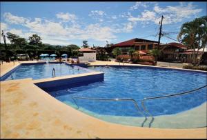 a large pool with blue water in a resort at Villa Paradise in Jacó