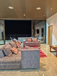 a living room with two couches and a flat screen tv at Estancia Mirador Reyes- Casa de la Montaña in Zamora