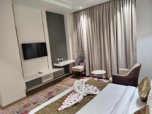 a hotel room with a bed and a desk at The Holy Awadh Hotel in Ayodhya