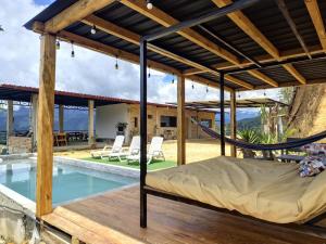 a bed under a pergola next to a swimming pool at Estancia Mirador Reyes- Casa de la Montaña in Zamora