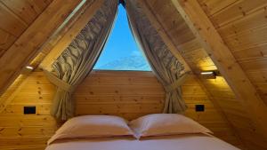 a bed in a room with a window at Konispol Mandarin Cabin in Mursi