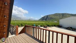 a wooden deck with a view of a field at Konispol Mandarin Cabin in Mursi