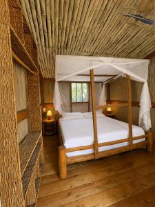 a bedroom with a canopy bed in a room at Stay Social Diani - Backpackers & Social Hub in Diani Beach