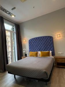 ein Schlafzimmer mit einem großen Bett mit blauem Kopfteil in der Unterkunft Hotel Ginebra in Barcelona + 94 Fotos