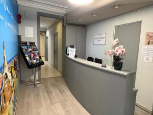 eine Lobby mit Rezeption und Blumen an der Wand in der Unterkunft Hotel Ginebra in Barcelona