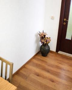 a vase with flowers sitting on a floor next to a door at Adori Boutique in Eforie Nord +5 photos