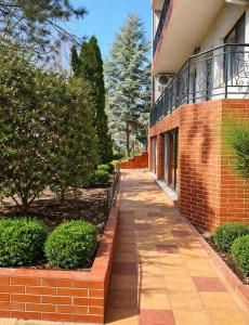 a brick walkway next to a building with trees at Adori Boutique in Eforie Nord