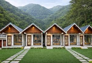a large house with mountains in the background at Kanchankanya Hill Resort in Takdāh