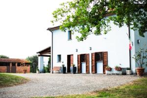 a white building with doors and a gravel driveway at Casina di Leonardo Arezzo in Arezzo
