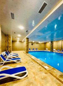 a swimming pool with lounge chairs in a hotel at Siena Suite Tsaghkadzor in Tsaghkadzor
