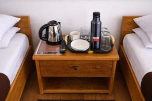 a tray with a coffee maker on a table between two beds at Kanchankanya Hill Resort in Takdāh