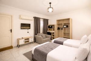 a hotel room with two beds and a chair at Nile X Hostel - Nile view in Cairo