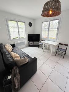 a living room with a black couch and a table at Maison 1 chambre in Hyères