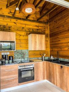 a kitchen with wooden cabinets and a stove at Bohème Chic, 2 Suites, Terrasse XXL in Le Gosier +14 photos