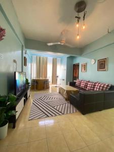 a living room with a couch and a tv at Homestay Plaza in Temerloh