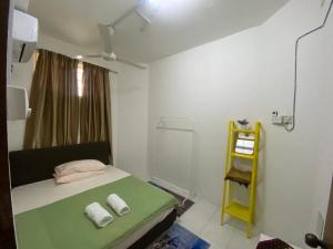 a small room with a bed and a yellow shelf at Homestay Plaza in Temerloh