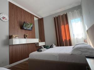 a bedroom with a bed and a clock on the wall at Agnesa Apartament in Gramsh
