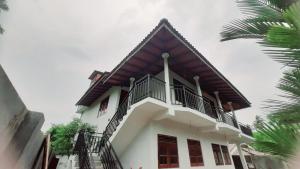a white house with a gambrel roof at Anchor House in Ahangama