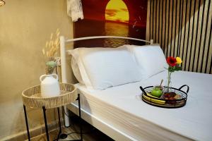 a bed with a bowl of fruit and a basket of flowers on it at The Nest in Astris