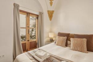 a bedroom with a white bed with a window at The Farm Lodge in Marbella