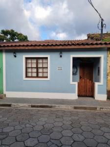 a blue and white house with a door at Suítes da Sereia in Cananéia