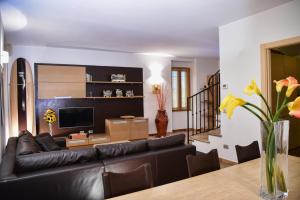 a living room with a black leather couch and a table at Roncati Family Apartment in Bellagio