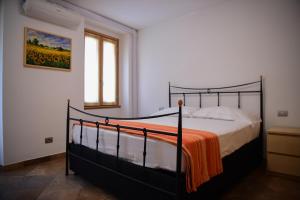 a bedroom with a bed with an orange blanket at Roncati Family Apartment in Bellagio