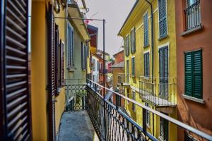 an alley in an old town with yellow and green buildings at Roncati Family Apartment in Bellagio