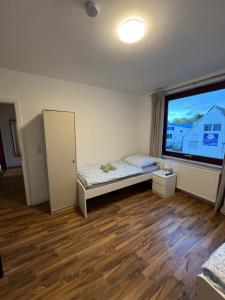 a bedroom with a bed and a large window at Haven Lodge Komfortable Unterkunft für Monteure, Firmen und Gruppen in Bremerhaven in Bremerhaven