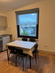 a table and chairs in a room with a large window at Haven Lodge Komfortable Unterkunft für Monteure, Firmen und Gruppen in Bremerhaven in Bremerhaven