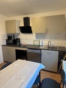 a kitchen with a table and chairs and a counter top at Haven Lodge Komfortable Unterkunft für Monteure, Firmen und Gruppen in Bremerhaven in Bremerhaven +7 photos