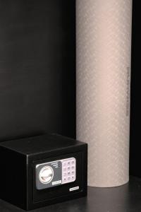 a black microwave next to a roll of toilet paper at The Ruler Bali in Penginyahan