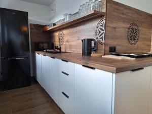 a kitchen with white cabinets and a black refrigerator at U Hajduka in Murzasichle