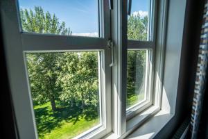 an open window with a view of a tree at Gistihúsið - Lake Hotel Egilsstadir in Egilsstaðir