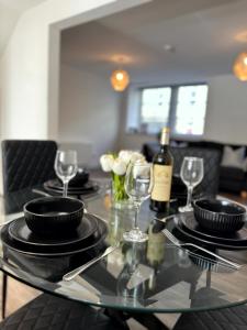 a glass table with glasses and wine bottles on it at Central 3BR home with Parking in Aberdeen +27 photos