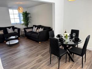 a living room with a table and chairs and a couch at Central 3BR home with Parking in Aberdeen