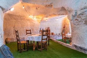 a dining room with a table and chairs in a cave at Parnaydisiaque in Parnay