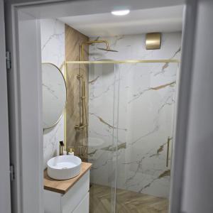 a bathroom with a glass shower and a sink at Apartament "Agatka" in Hel +12 photos