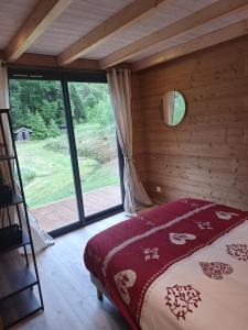 a bedroom with a bed in a room with a window at Chalet des Briseux in Saint-Maurice-sur-Moselle