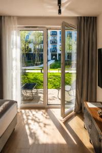 a bedroom with sliding glass doors with a view of a yard at Apart Studio Śródmieście in Gdańsk