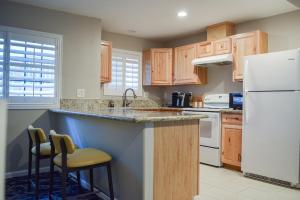 a kitchen with wooden cabinets and a white refrigerator at Creekside Inn Downtown in Cambria