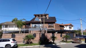 a brick house with a white car parked in front of it at VICTORIA 3 BED AND BREAKFAST A 3KM DEL AEROPUERTO EZEIZa in Ezeiza