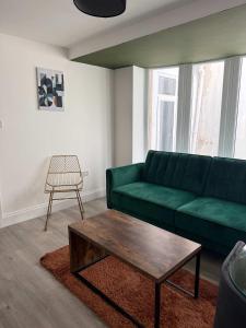 a living room with a green couch and a coffee table at Ground Floor Flat with Courtyard garden in Weston-super-Mare