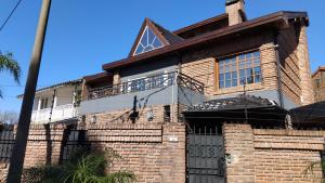 a brick house with a balcony on top of it at VICTORIA 3 BED AND BREAKFAST A 3KM DEL AEROPUERTO EZEIZa in Ezeiza