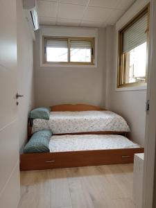 a small bedroom with a bed and two windows at D'Canteira in Redondela