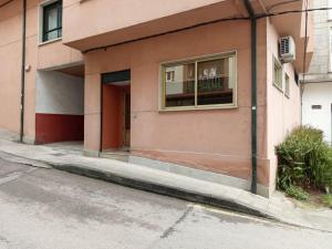 a pink building with a window on a street at D'Canteira in Redondela