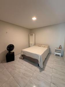 a bedroom with a bed in the corner of a room at Comfort Ton House in Juazeiro do Norte