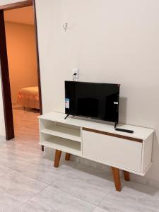 a white entertainment center with a flat screen tv on it at Comfort Ton House in Juazeiro do Norte