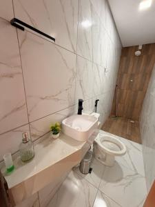 a white bathroom with a sink and a toilet at Comfort Ton House in Juazeiro do Norte +14 photos