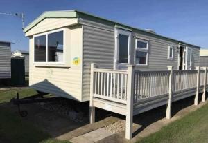 a grey and white tiny house with a fence at Home from home 2 in Ingoldmells